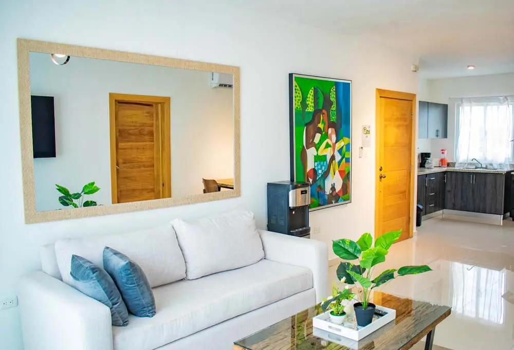 Living room with mirror and kitchen in the penthouse at Beach Apartamentos in Playa Palmera